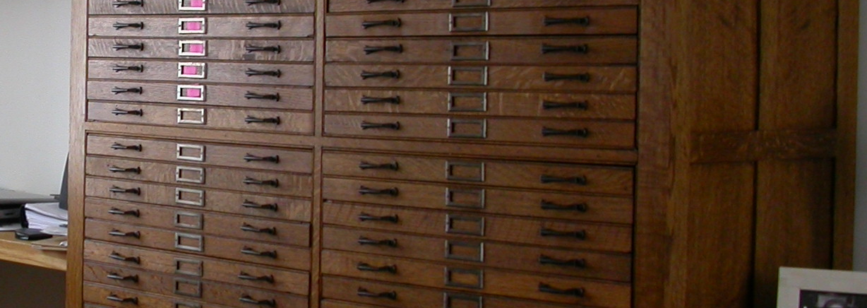 Oak printer's type-storage cabinets, used as anchors for a large White Oak desk, and to house a coin collection.